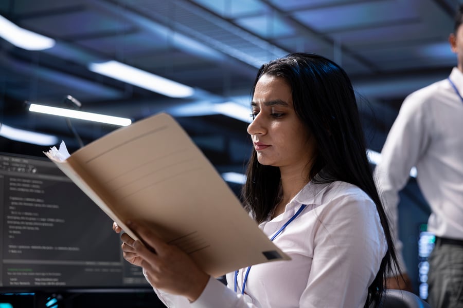 A woman reads over a folder in an office building