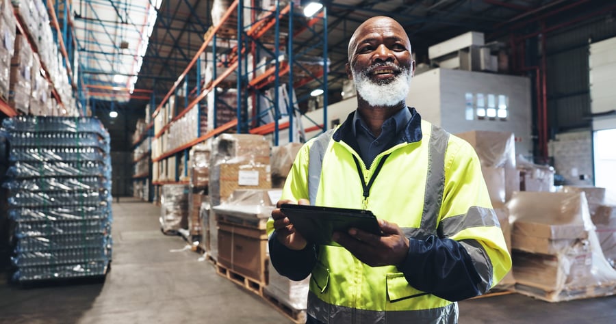 A man holding a tablet in a warehouse