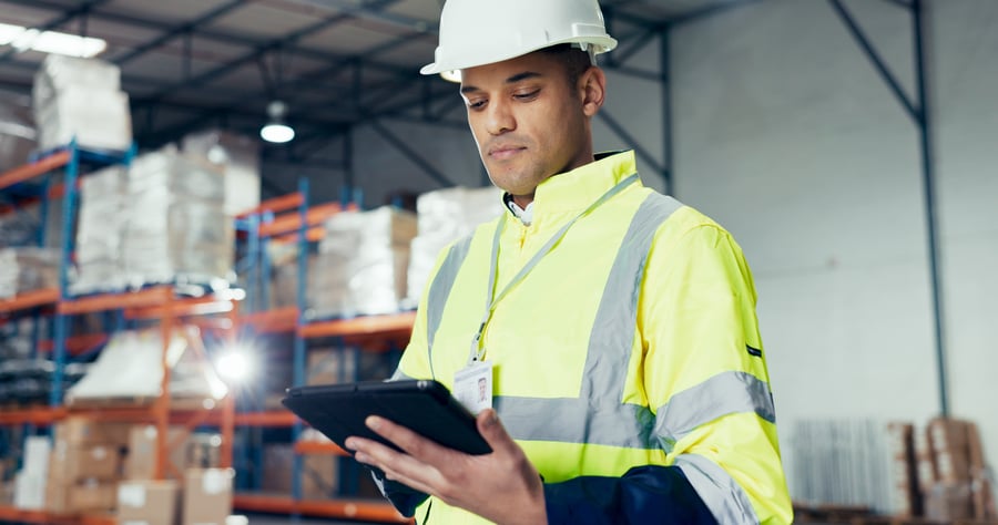 A man checking something on a tablet in a warehouse