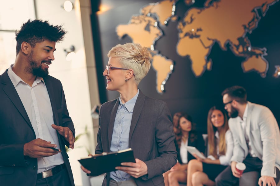 An office discussing work in front of a world map